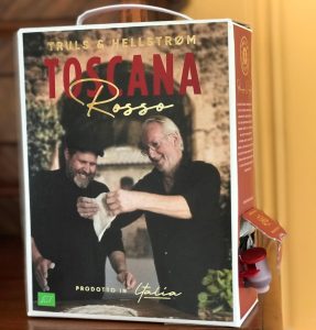 Boksvin med bilde på etiketten av to smilende menn og med teksten "Toscana rosso"